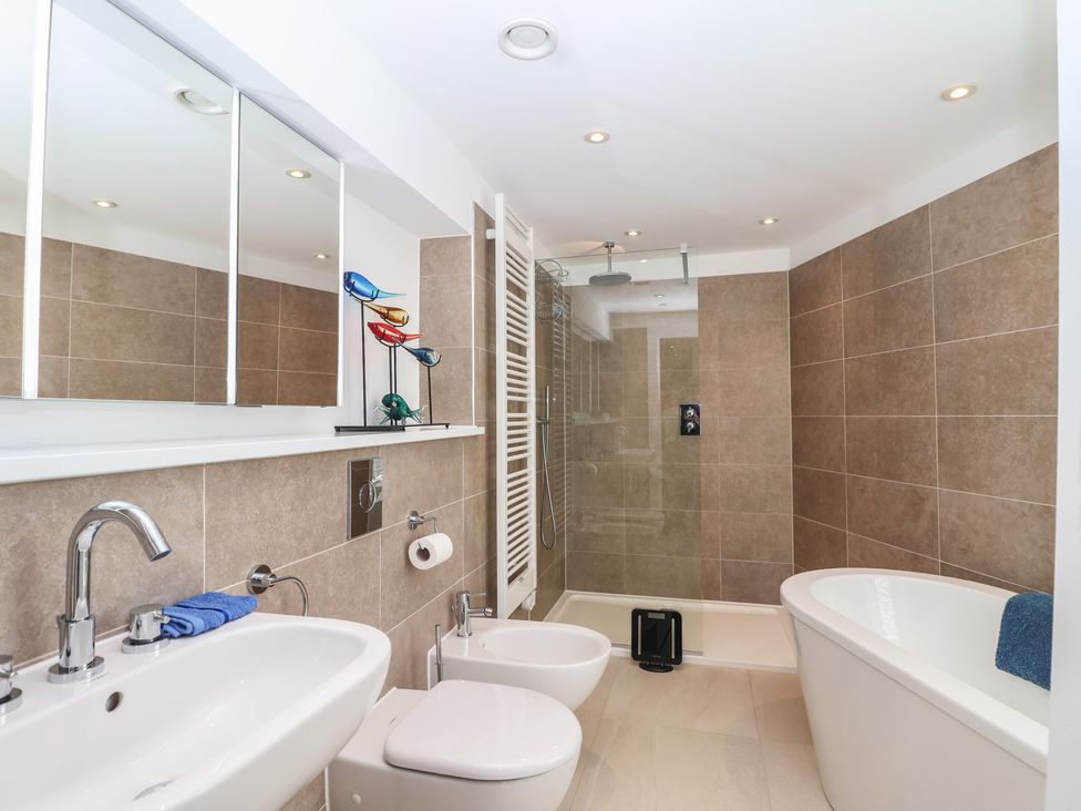 A bathroom with a bathtub, shower, sink and toilet at 5 Sails in Dartmouth