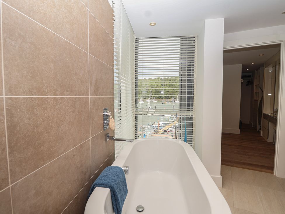 A bathroom with a bathtub and window at 5 Sails in Dartmouth