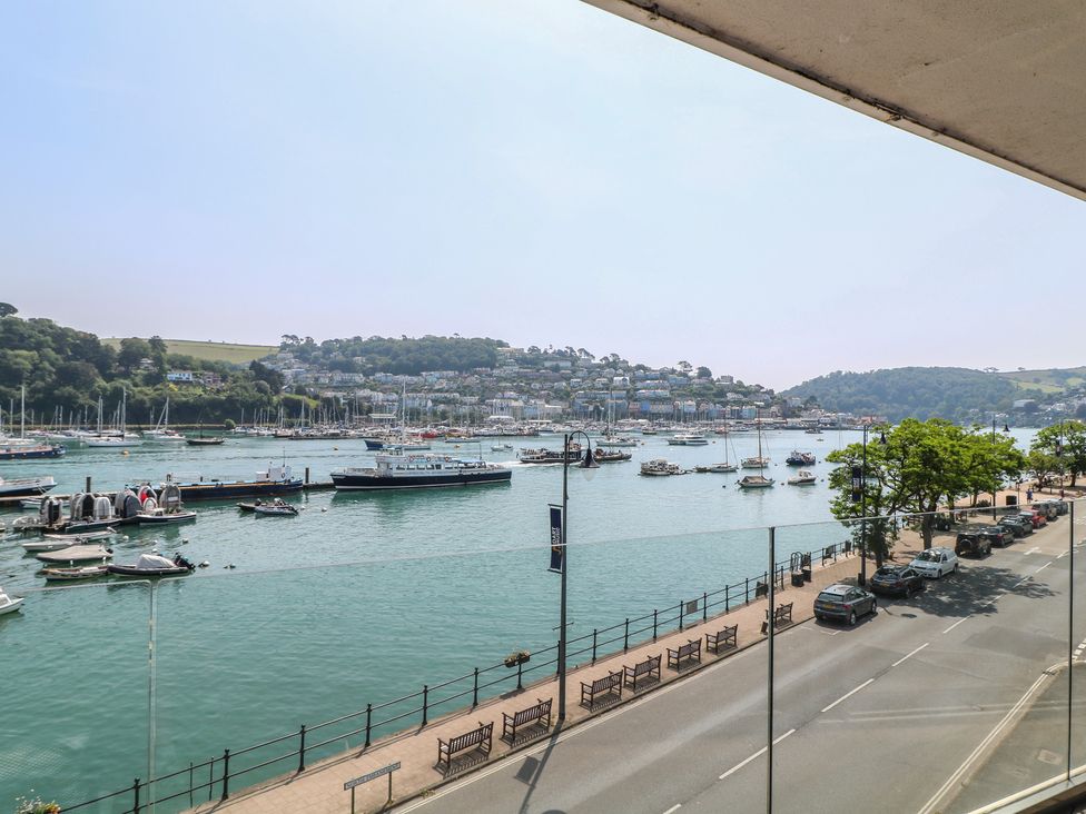 A view of boats on the water and a street lined with benches at 5 Sails Dartmouth