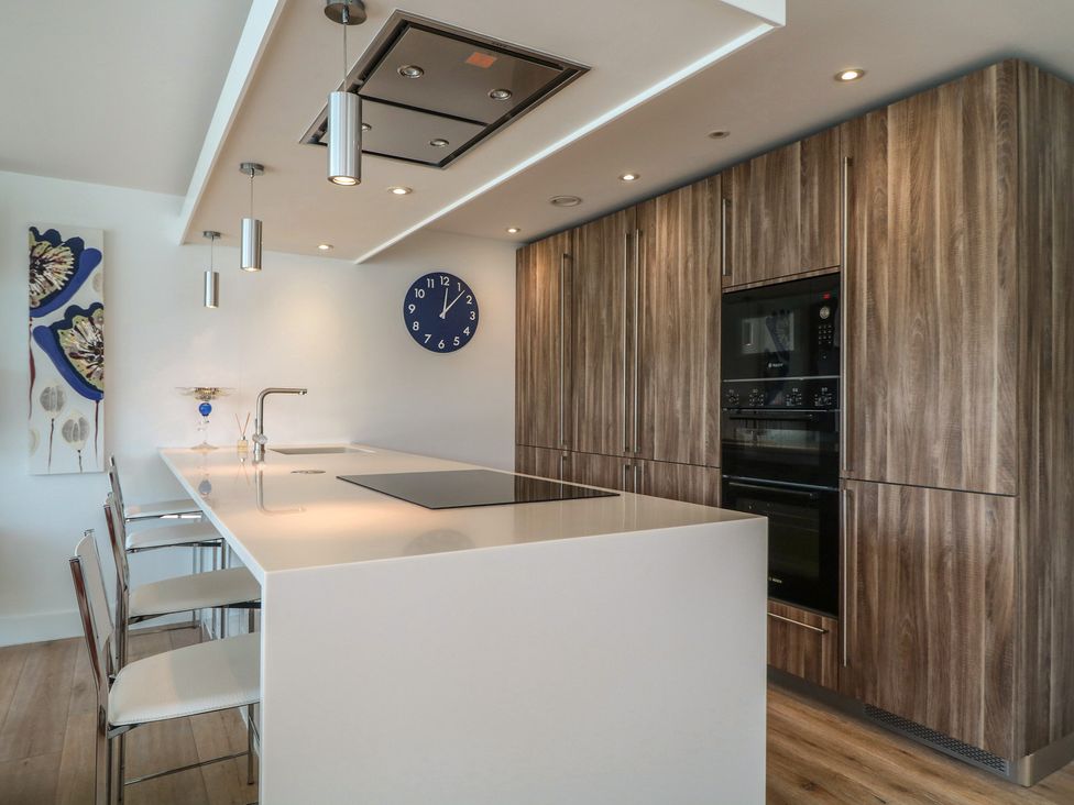 A kitchen with a large island and bar stools at 5 Sails in Dartmouth