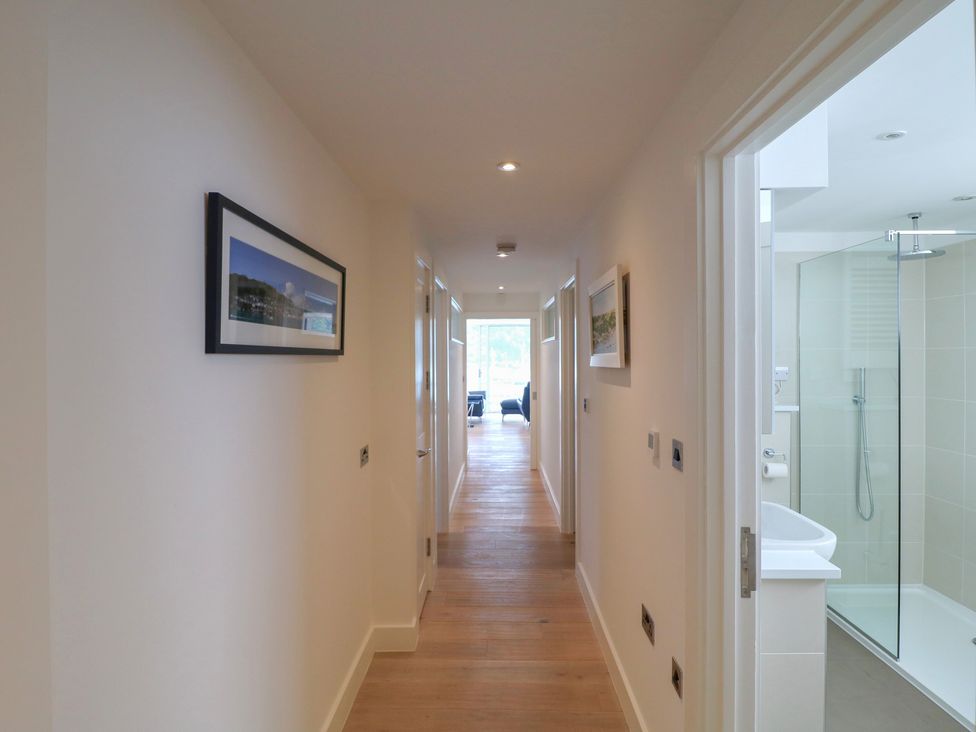A hallway with a shower visible and doors at 5 Sails in Dartmouth
