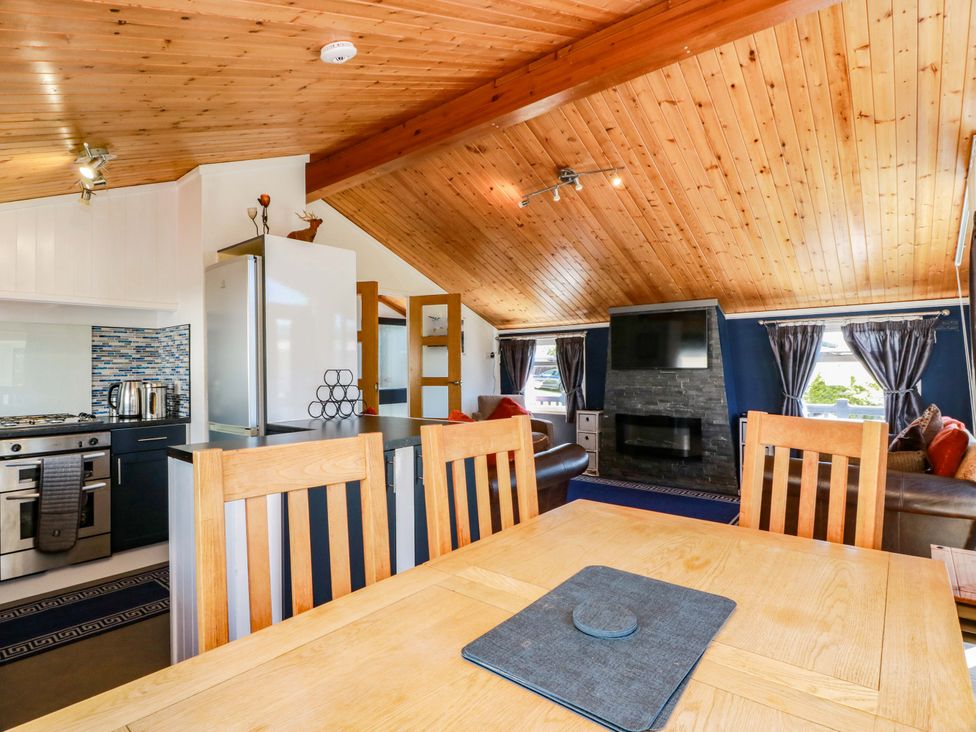 A kitchen and living room area with a dining table at Queensway QW1 Dumfries