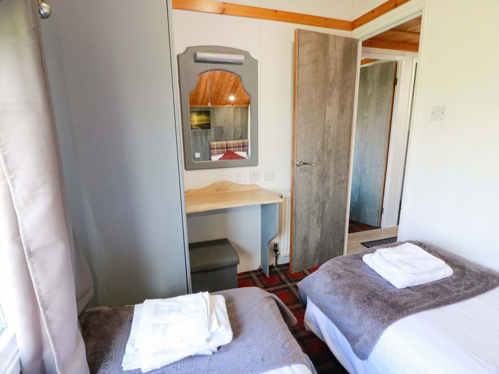 A bedroom with two single beds and a mirror on a desk at Queensway QW1, Dumfries
