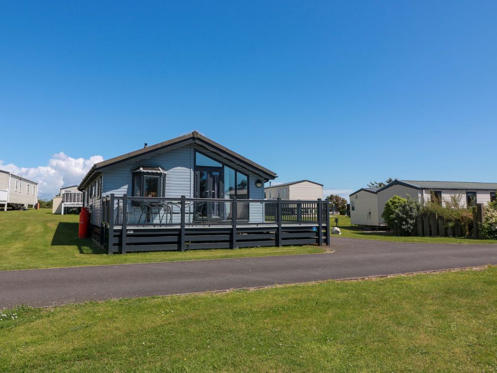 A house with a deck and chairs at Queensway QW1 Dumfries