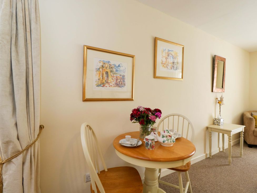 A dining room with a table set for tea at The Garden Studio in Bremhill near Calne