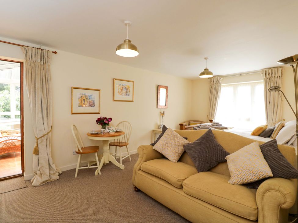 A living room with a sofa and dining area at The Garden Studio in Bremhill near Calne