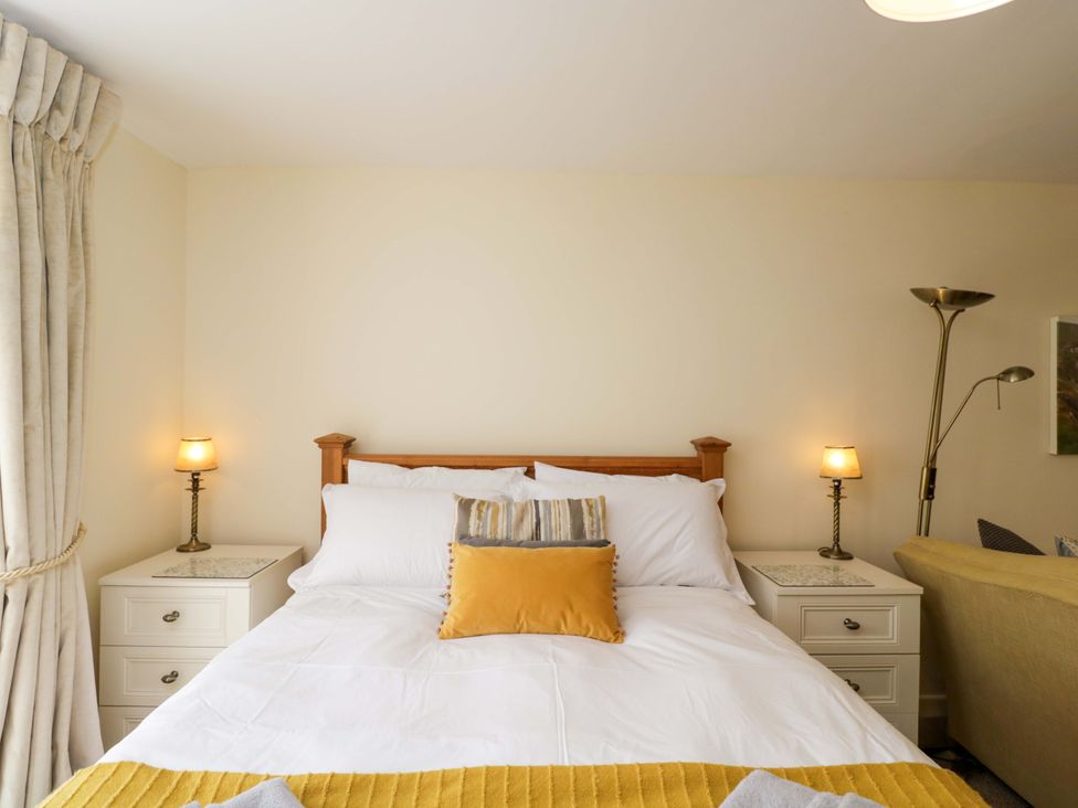 A bedroom with a bed and nightstands at The Garden Studio in Bremhill near Calne