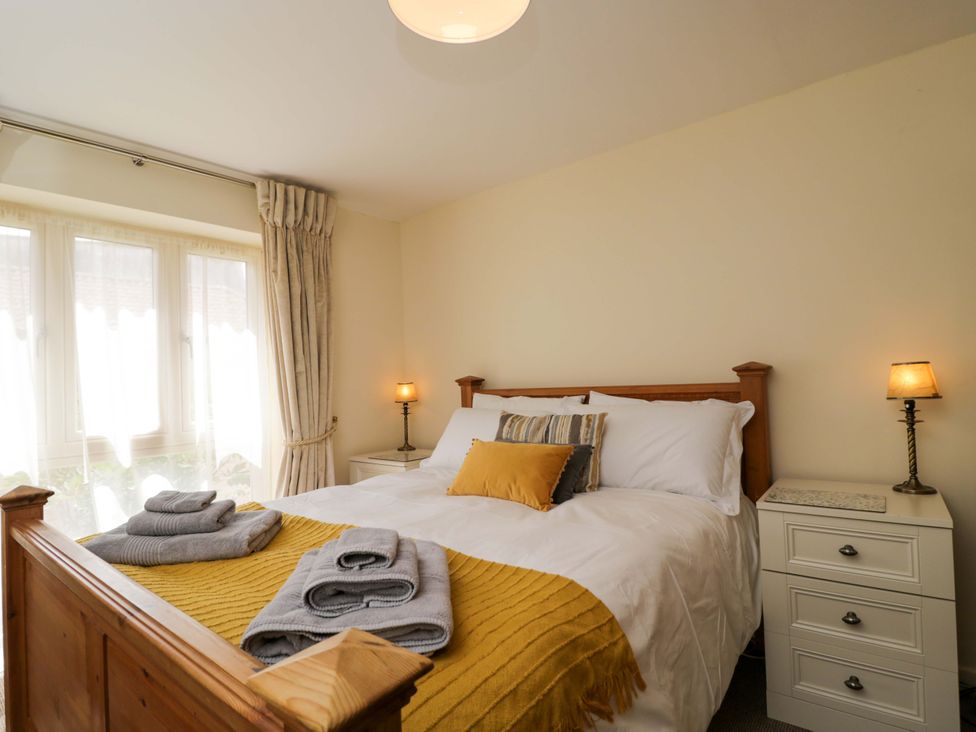 A bedroom with a bed and bedside lamp at The Garden Studio in Bremhill near Calne