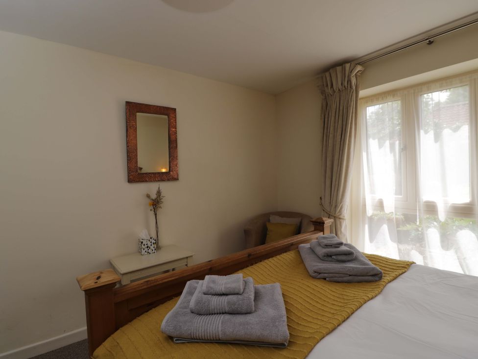 A bedroom with a bed and towels on top at The Garden Studio in Bremhill near Calne