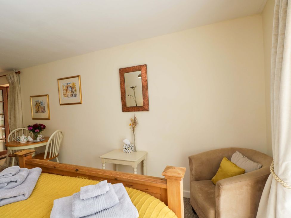 A bedroom with a bed and side table at The Garden Studio Bremhill near Calne