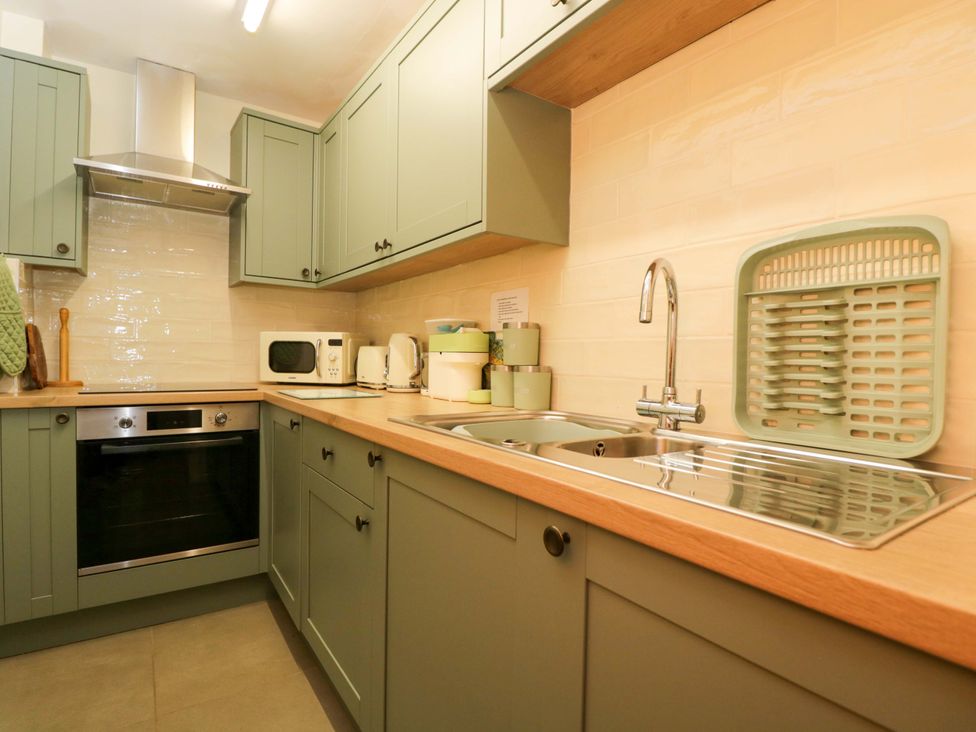 A kitchen with cabinets and appliances at The Garden Studio in Bremhill near Calne