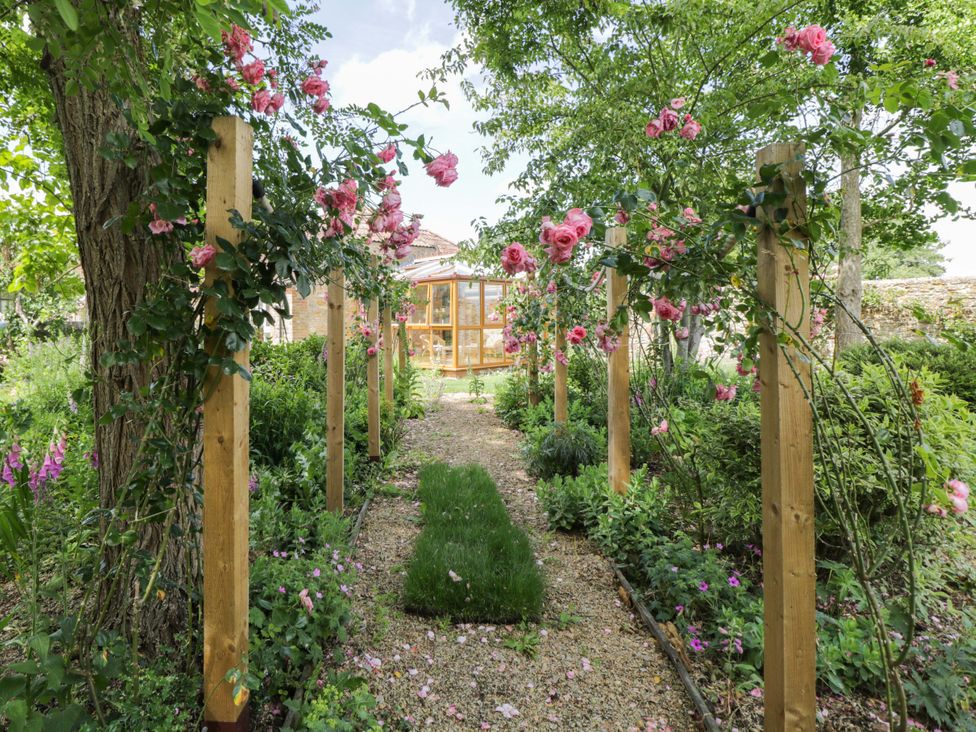 A garden with flowers and a pathway at The Garden Studio in Bremhill near Calne