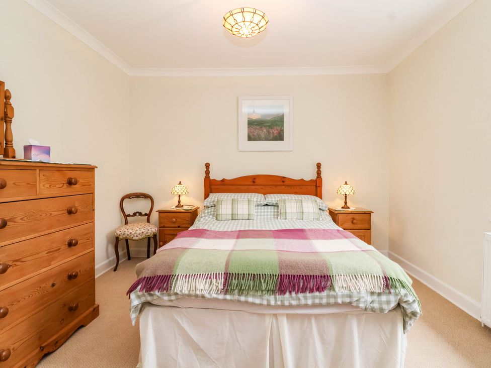 A bedroom with a bed and wooden furniture at 96 Chapel Lane Butleigh