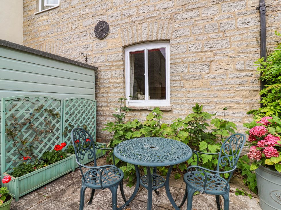 A small outdoor seating area with a table and chairs at 96 Chapel Lane Butleigh