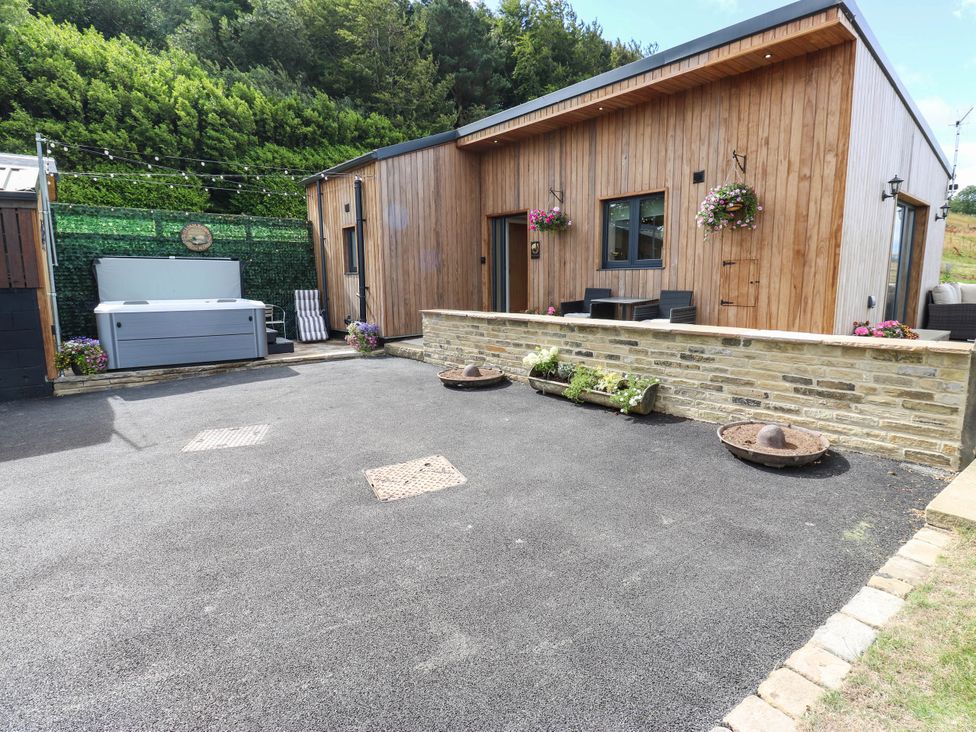 An outdoor area with a hot tub and seating at The Stables in Stainland