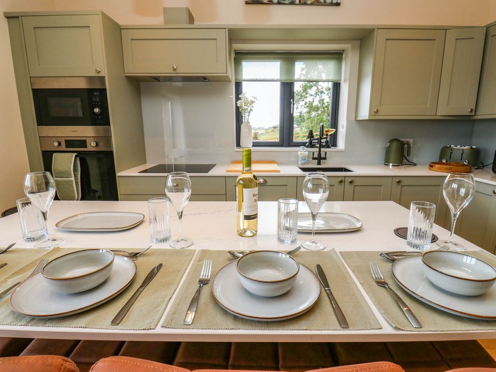 A kitchen with dining setup and appliances at The Stables in Stainland