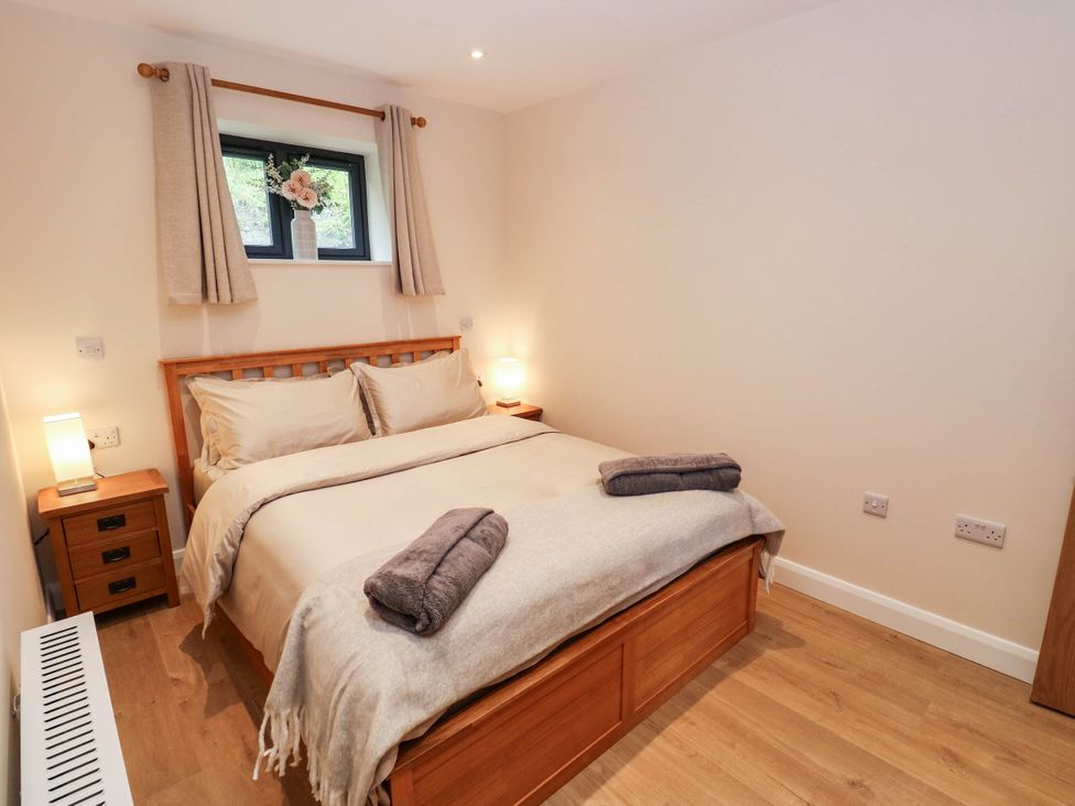A bedroom with a double bed and nightstand at The Stables in Stainland