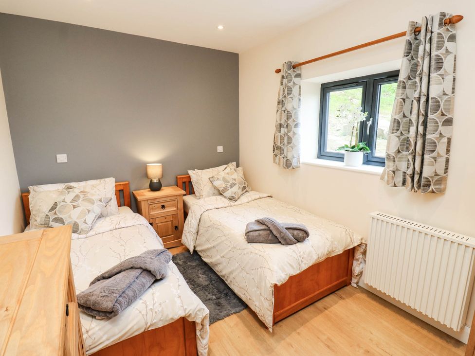 A bedroom with two beds and a window at The Stables in Stainland