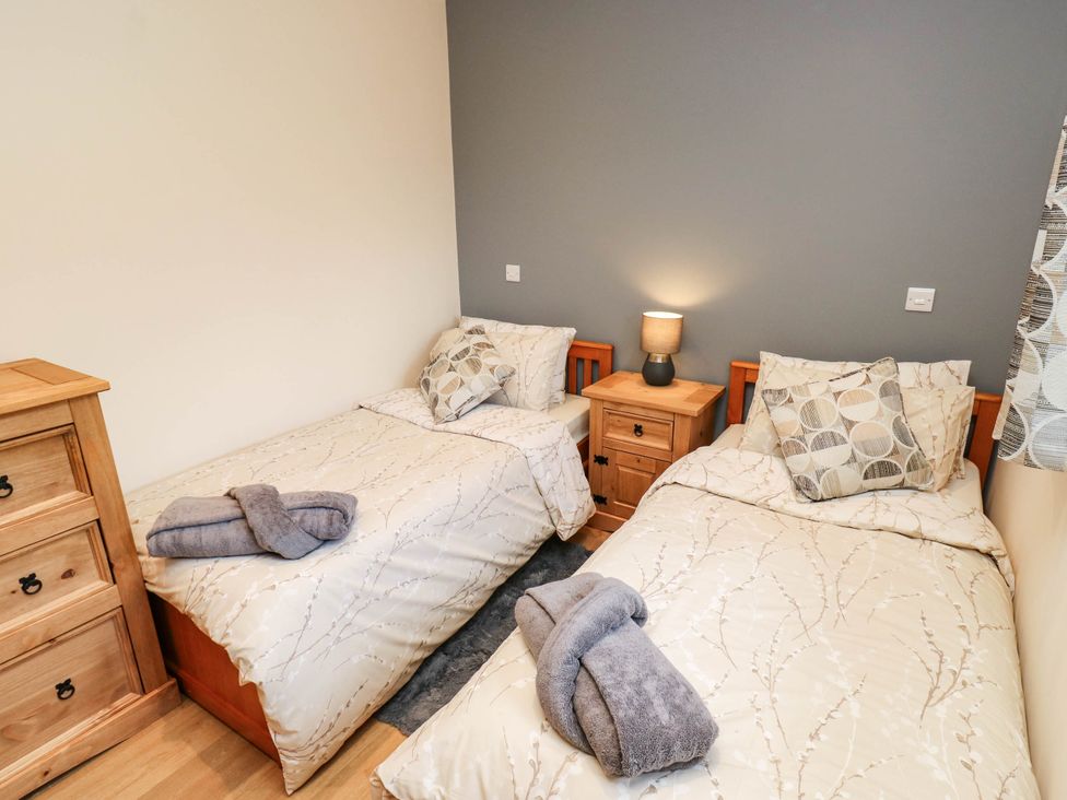 A bedroom with twin beds and a nightstand at The Stables in Stainland