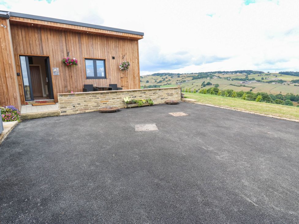 An outdoor area with wooden exterior and stone wall at The Stables in Stainland