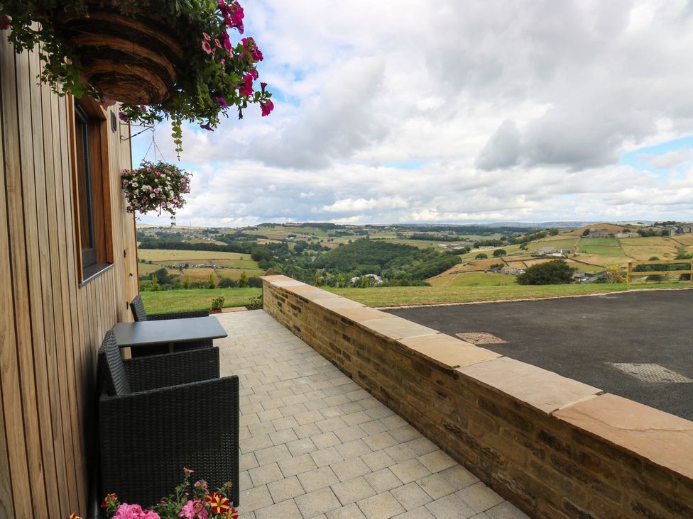 An outdoor area with a table and chairs overlooking a landscape at The Stables in Stainland