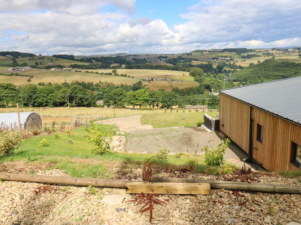 A view of fields and hills with a building at The Stables in Stainland