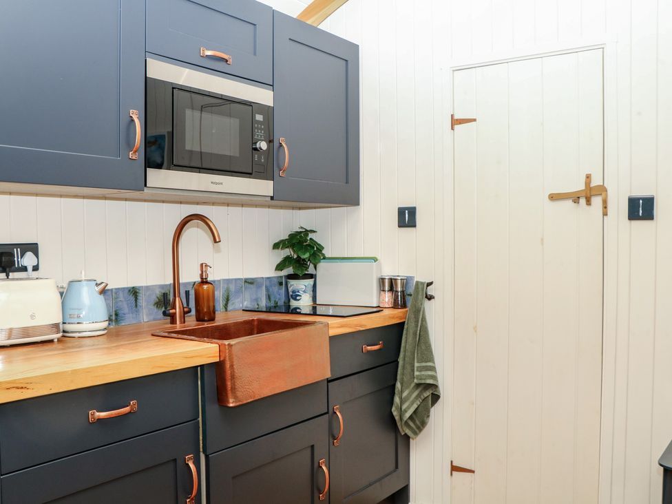 A kitchen with a sink and microwave at Ridden Brake shepherds hut Yelverton
