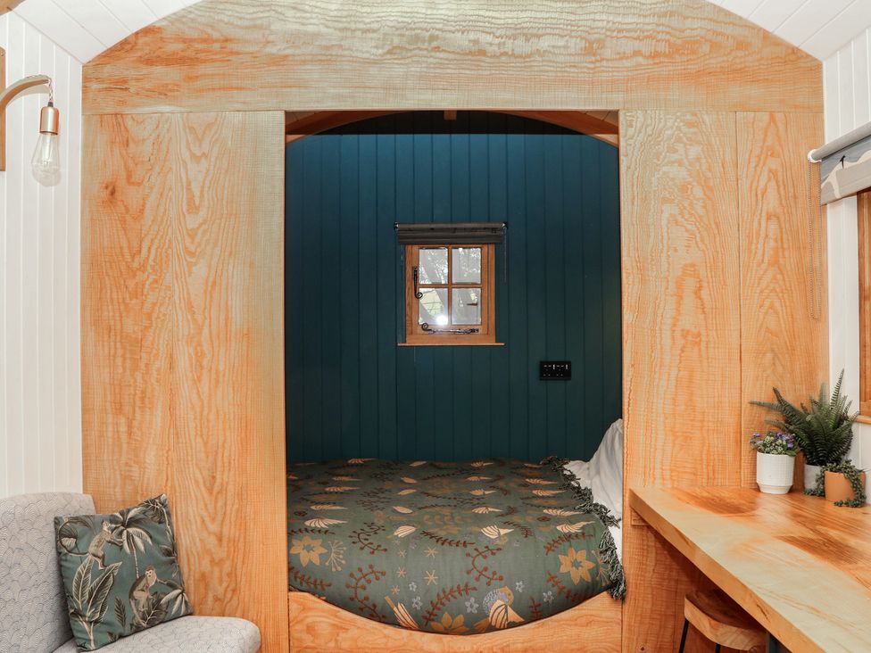 A bedroom with a bed and window at Ridden Brake shepherds hut Yelverton