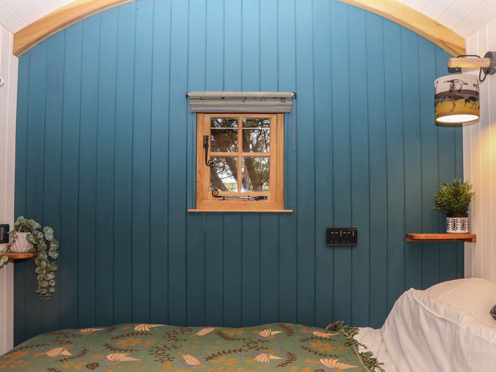 A bedroom with a window and bed at Ridden Brake shepherds hut in Yelverton