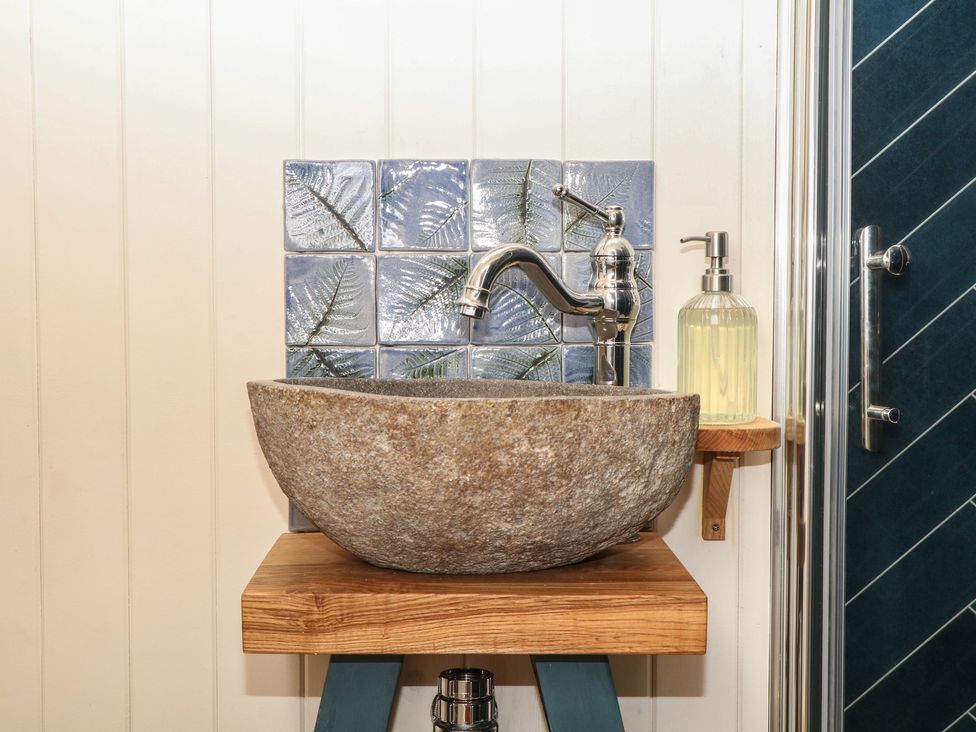 A sink with faucet and soap dispenser in the bathroom at Ridden Brake shepherds hut Yelverton