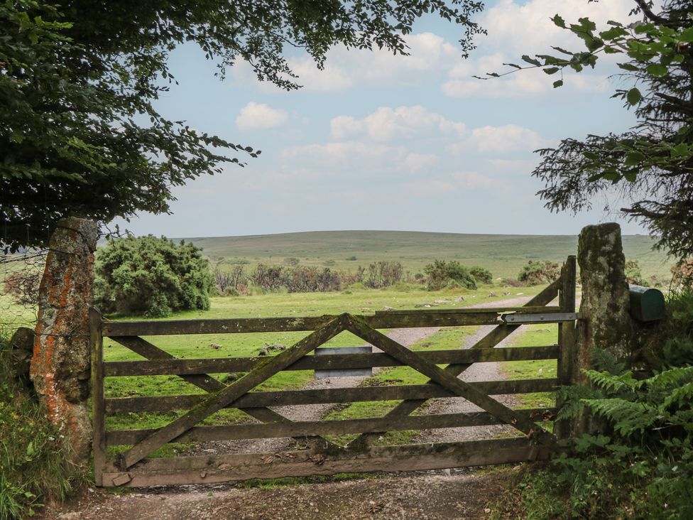 A wooden gate leading to a grassy field at Ridden Brake shepherds hut Yelverton