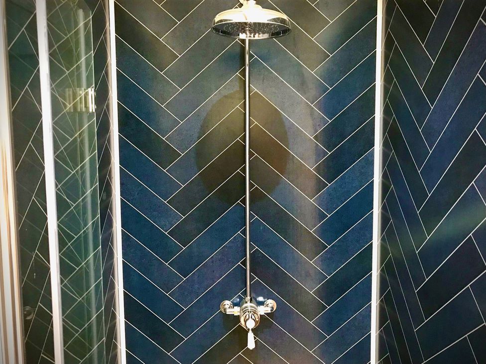 A shower with a showerhead and valve at Goldcrest in Postbridge