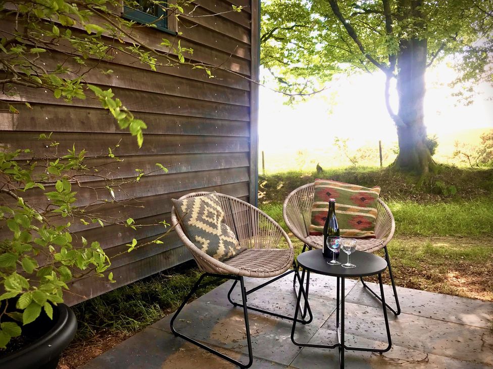 An outdoor seating area with a table and chairs at Goldcrest in Postbridge