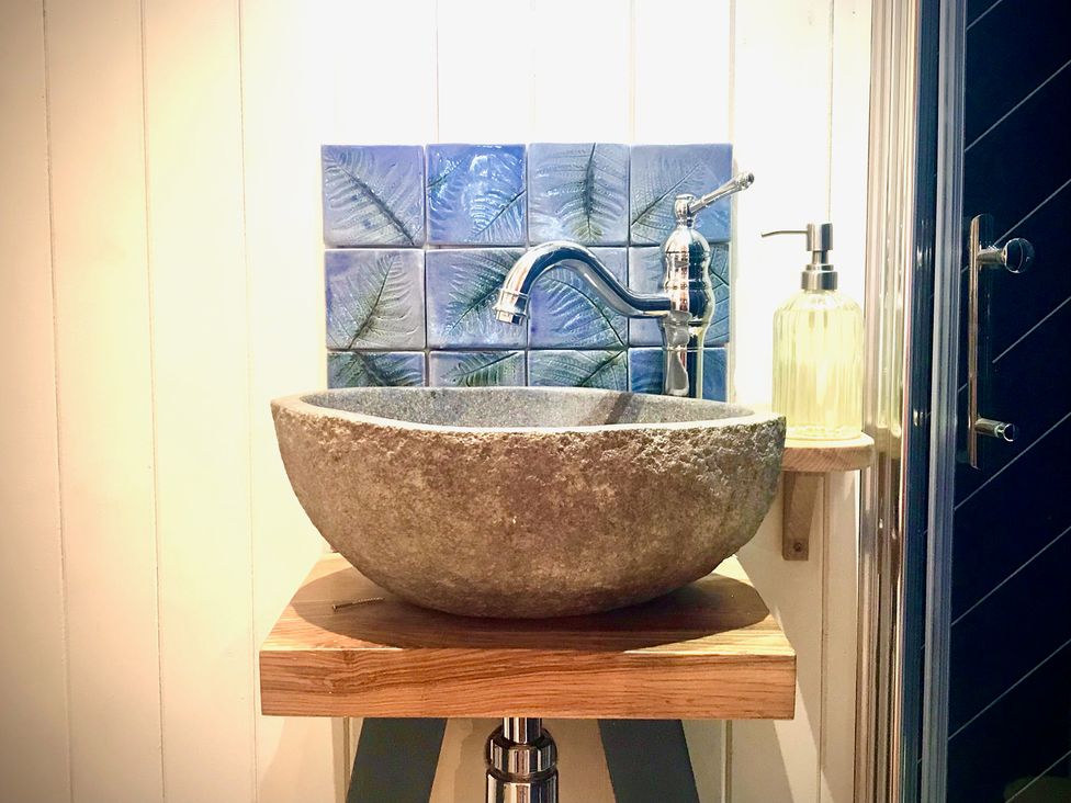 A sink with a stone basin and faucet in a bathroom at Goldcrest in Postbridge
