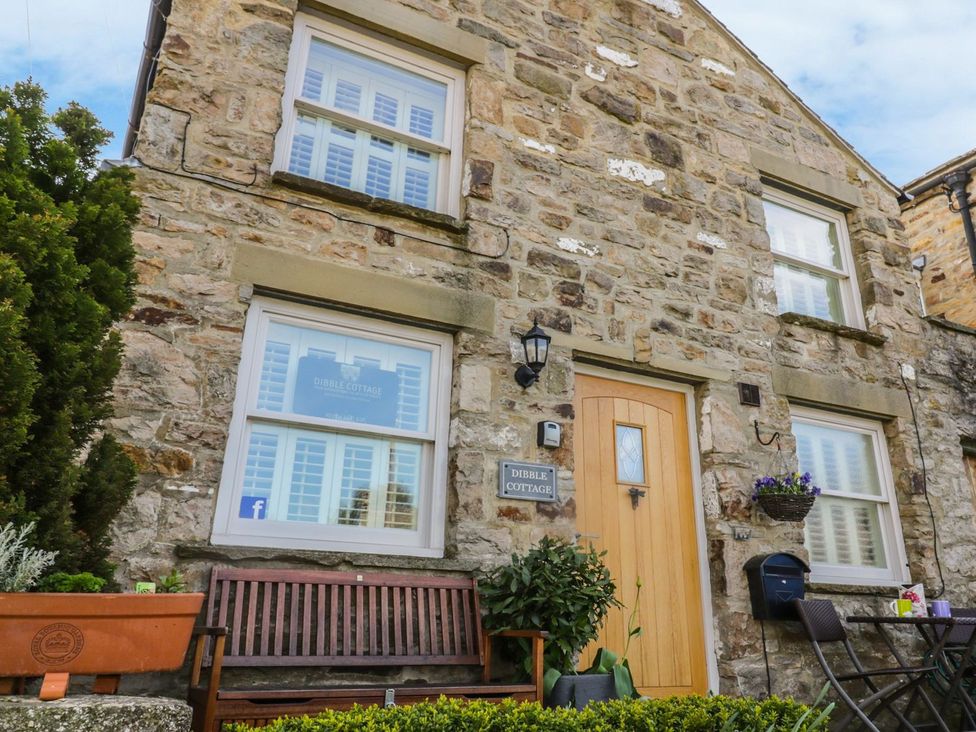 A stone cottage with a bench and plants at Dibble Cottage in Richmond