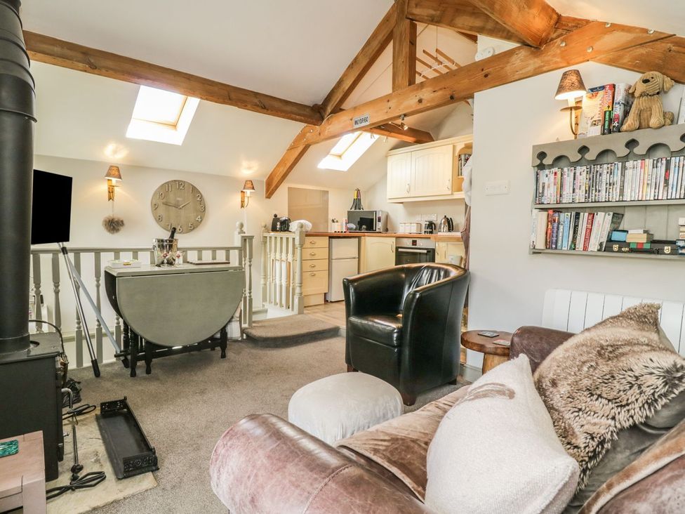 A living room with a sofa, armchair, and dining table at Dibble Cottage in Richmond