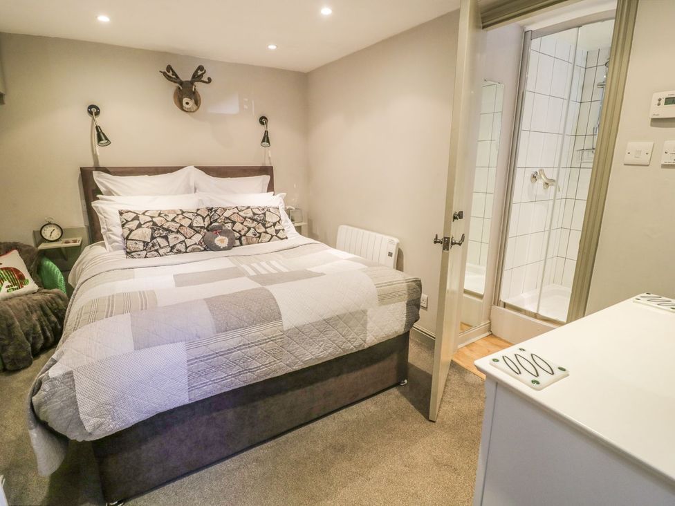 A bedroom with a bed and shower area at Dibble Cottage in Richmond