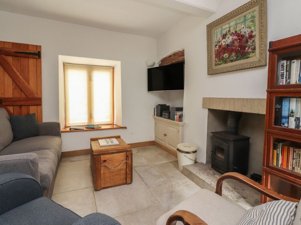 A living room with a coffee table and television at The Cottage in Giggleswick