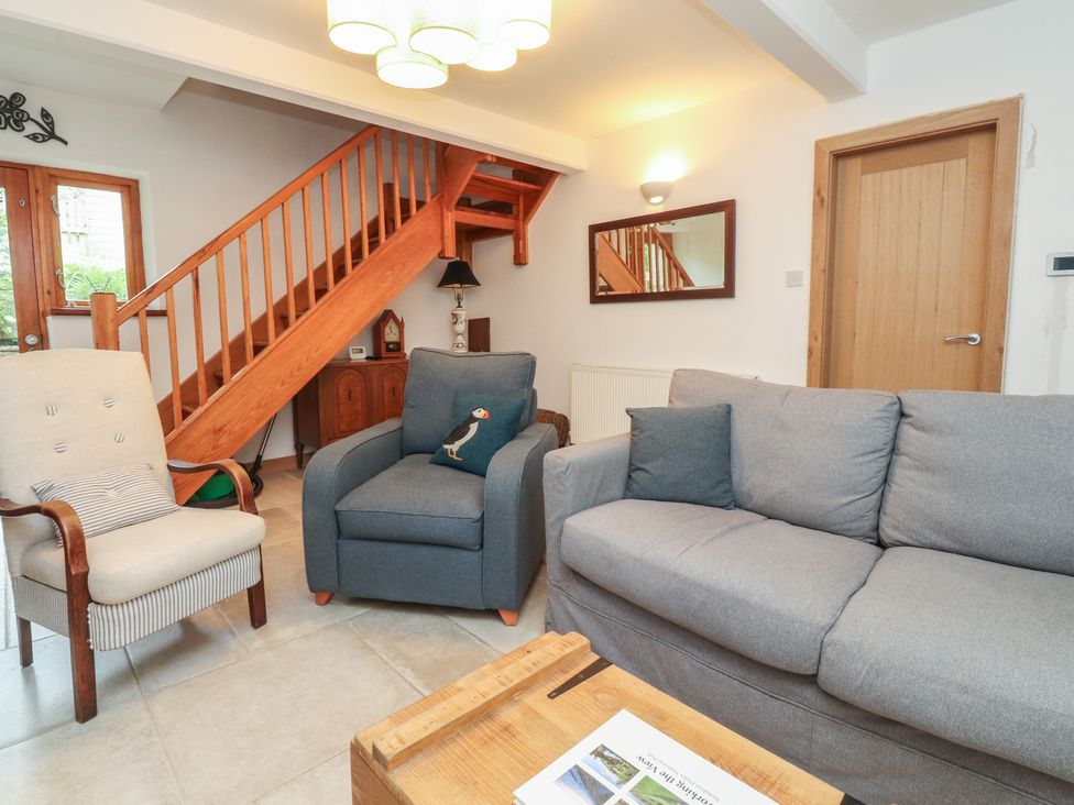 A living room with a staircase and seating area at The Cottage in Giggleswick