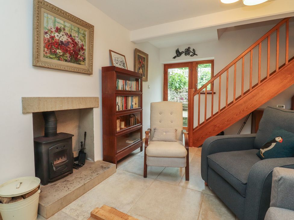A living room with a fireplace and bookshelves at The Cottage in Giggleswick