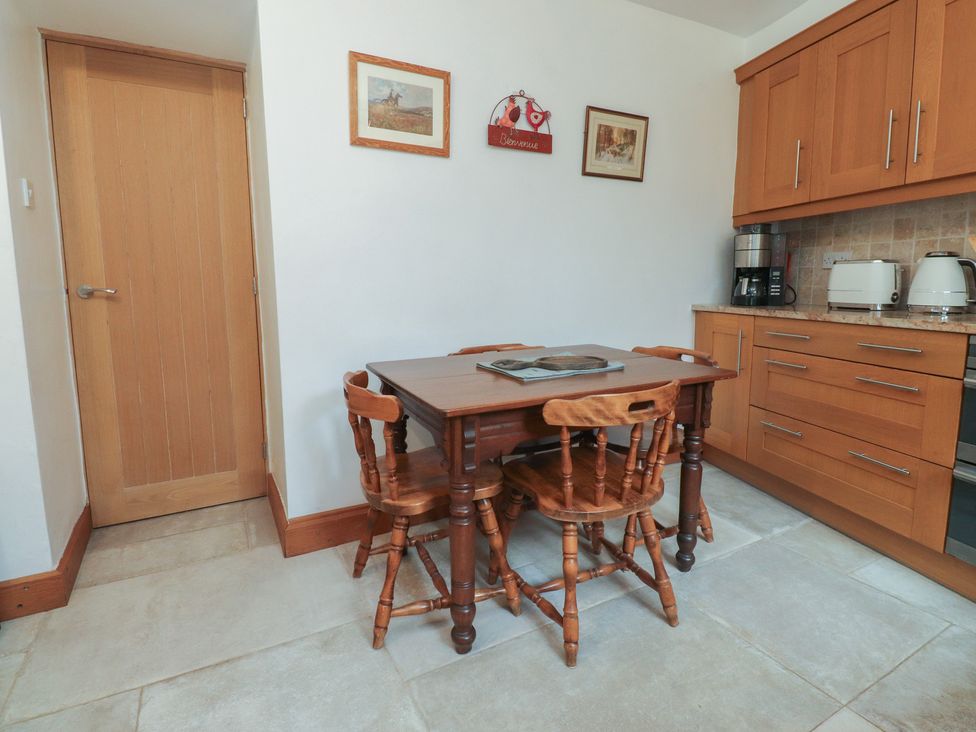 A kitchen with a table and chairs at The Cottage in Giggleswick
