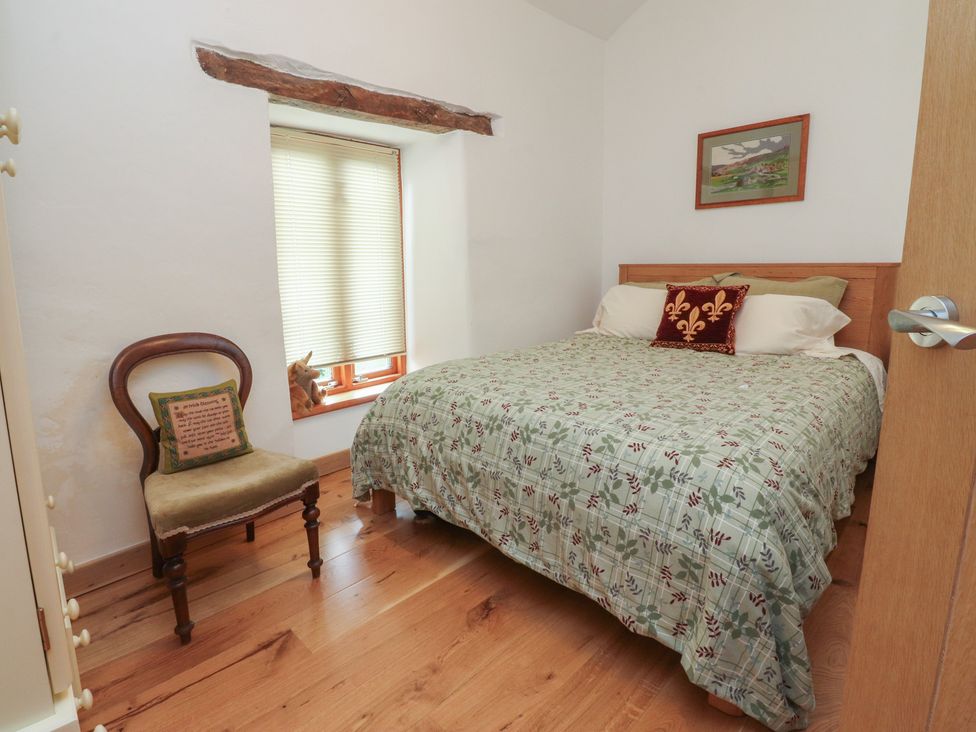 A bedroom with bed and chair at The Cottage in Giggleswick