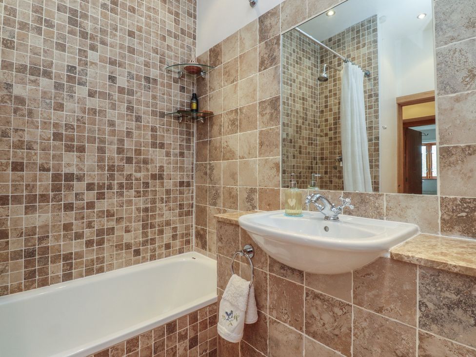 A bathroom with a bathtub and sink at The Cottage in Giggleswick