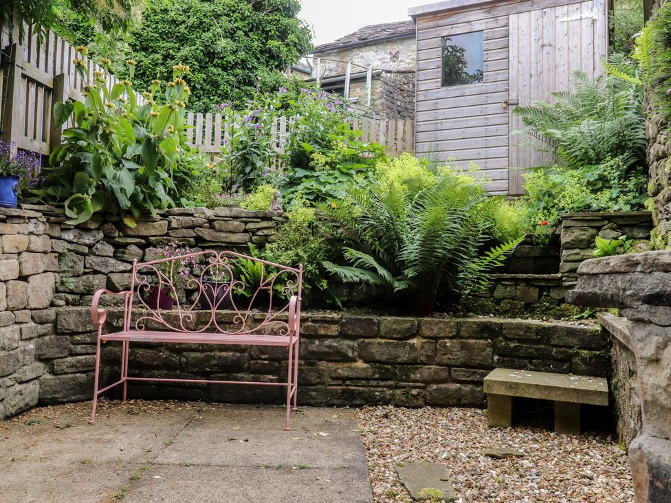 A garden with a bench and plants at The Cottage in Giggleswick