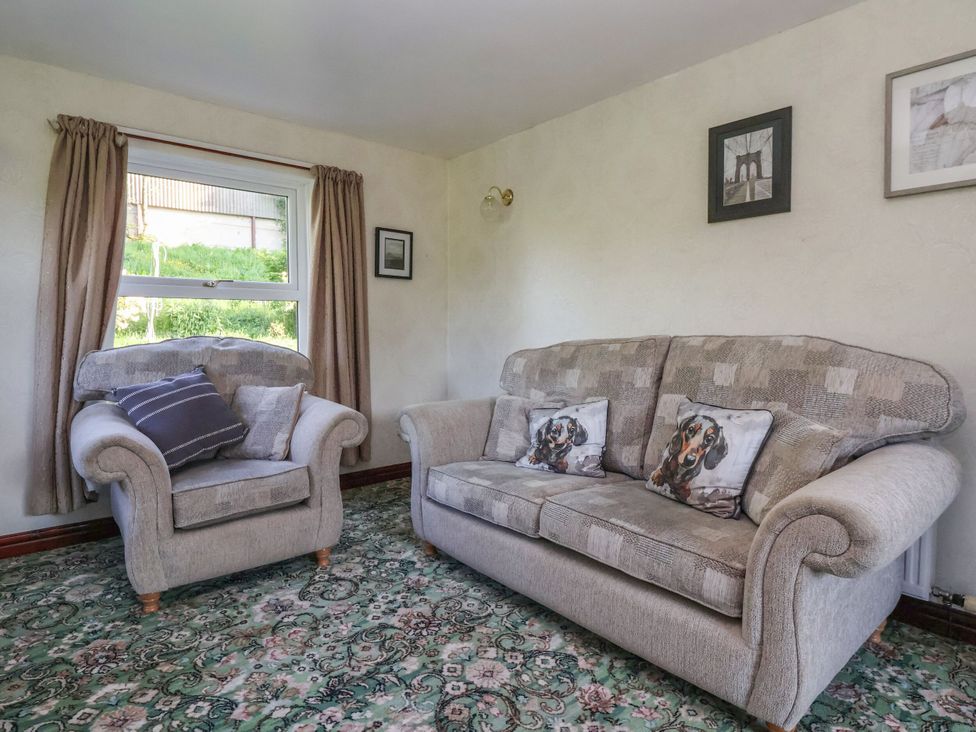 A living room with a sofa and armchair at Robin Hood Farmhouse in Keswick