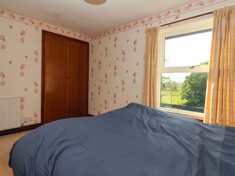 A bedroom with a bed and wardrobe at Robin Hood Farmhouse in Keswick