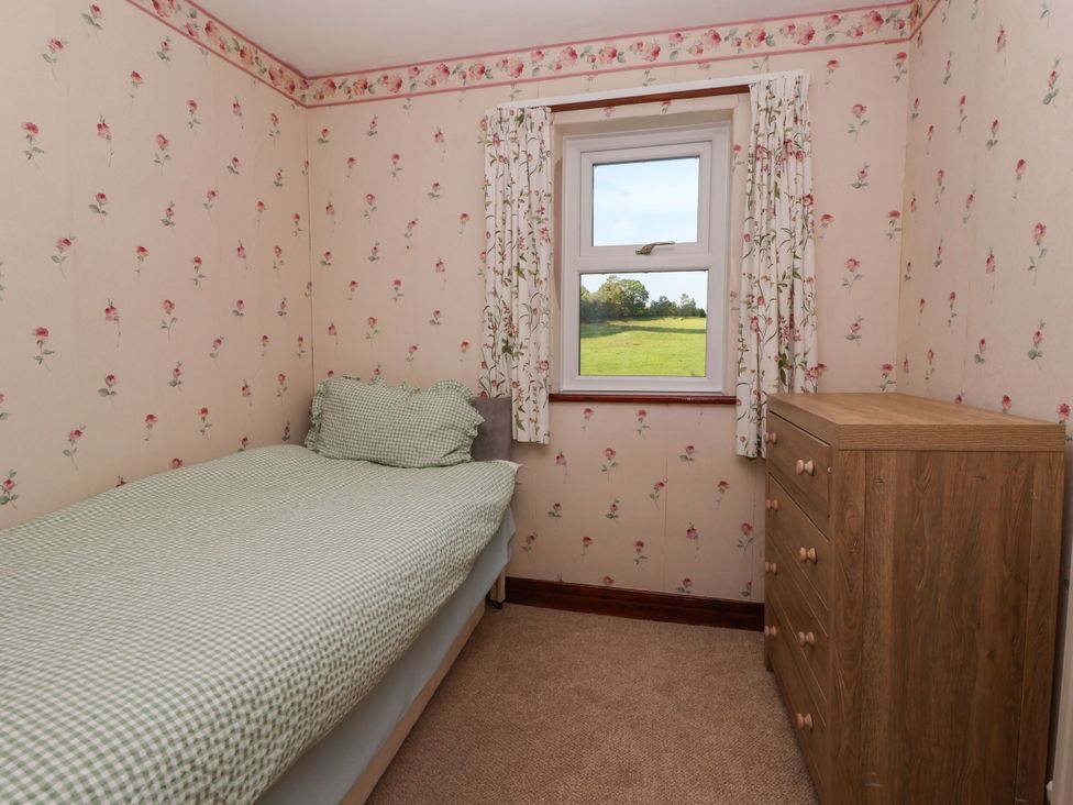 A bedroom with a bed and dresser at Robin Hood Farmhouse in Keswick