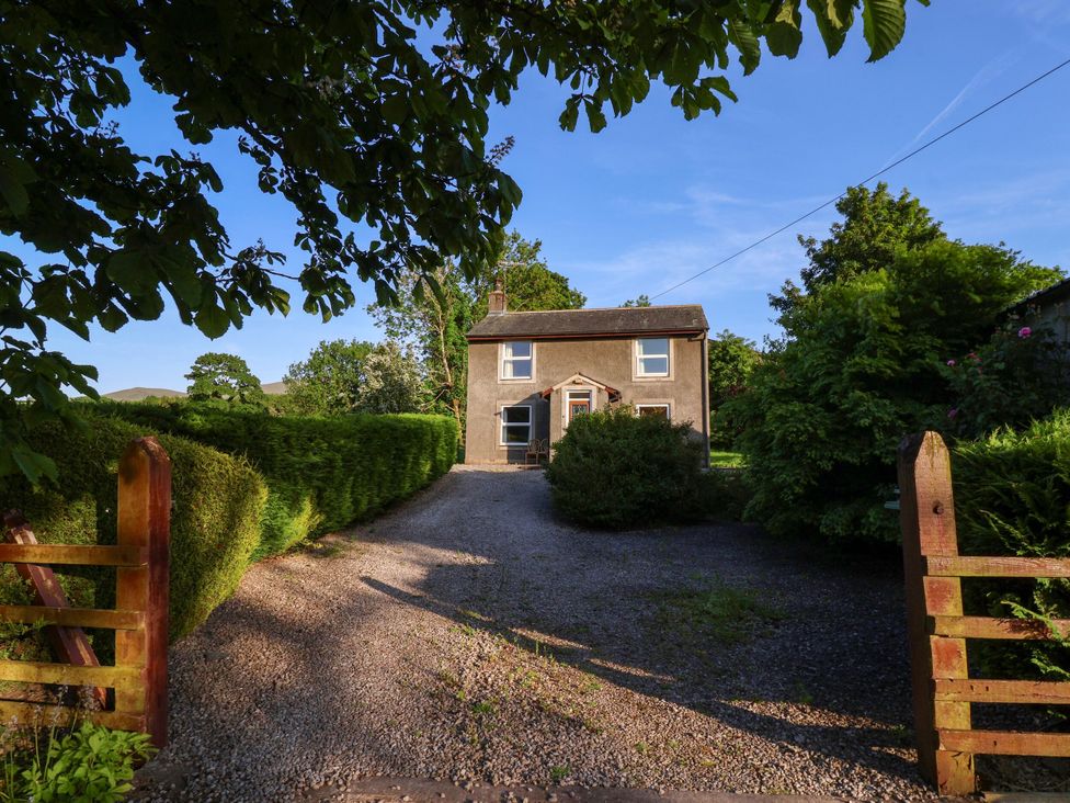 A house with a gravel driveway and gate at Robin Hood Farmhouse in Keswick