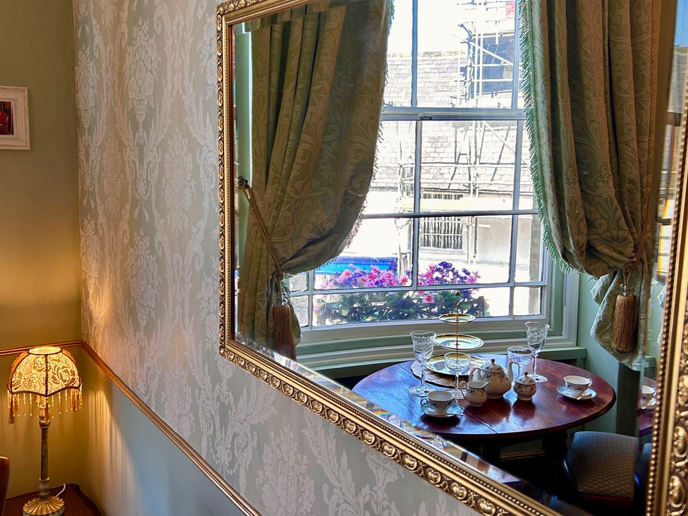 A dining room with a tea set and window view at Downton I in Alnwick