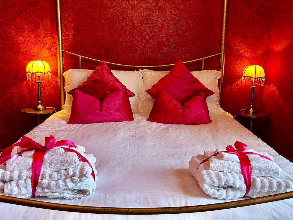 A bedroom with a bed, pillows, and towels at Downton I in Alnwick